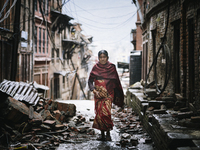 A Nepalese woman walking through a street littered with fallen debris following the 2015 earthquake in Nepal., Durbar Square, Bhaktapur, Nep...