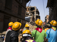 A team of volunteers wearing protective clothing wait for the all-clear instruction that will allow them to continue searching through the r...