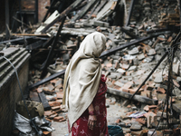 A woman inspects the damage to a neighbour's house following the 2015 earthquake in Nepal. The neighbour was killed beneath the falling buil...