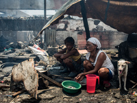 A woman prepares lunch outside the debris of her house destroyed by the fire that broke out in a slum area in Tondo, Manila in the Philippin...