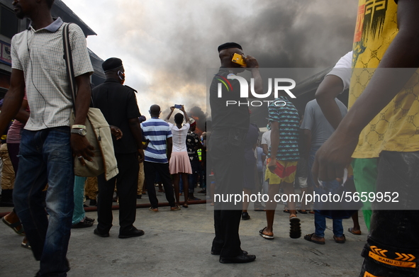 A police officer making a phone call at the scene of the fire outbreak at the Nigerian National Petroleum Corporation (NNPC) petrol station...