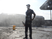 Man of fire fighter stand after putting a tanker which cut fire at the Nigerian National Petroleum Corporation (NNPC) petrol station located...
