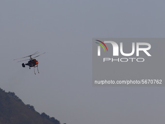 A firefighting helicopter carries out an operation to extinguish a forest fire in Goseong, some 160 kilometers northeast of Seoul, on May 2,...