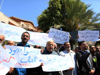 Palestinian workers hold banners during a protest demanding their rights in front of the Council of ministers headquarter, in Gaza city, on...