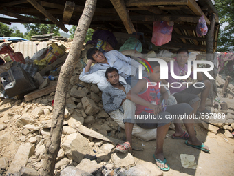 SINDHUPALCHOK, NEPAL-- May 5, 2015--A family takes shelter under the collapsed roof of a barn in the village of Jalkeni on the road between...