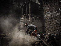 Affected family members are cleaning up debris of their destroyed house, in Katmandu, on May 5, 2015, following a 7.8 magnitude earthquake w...