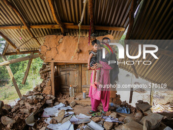 Kamala is standing with her daughter Nirjala in her destroyed house. Bandevi village, Kabrepalan Chowk, Nepal. May 6, 2015 (