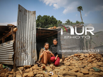 Shikha (left) and Sonu (right) are sitting infront of her destroyed house. Bandevi village, Kabrepalan Chowk, Nepal. May 6, 2015 (