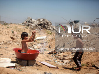 Palestinian children playing in the water  next to family home, which destroyed that witnesses said was destroyed during the 50-day war last...