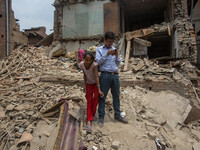 A man and her daughter are pictured as they are standing in the middle of the rubble where their house was before the earthquake.
2 weeks af...