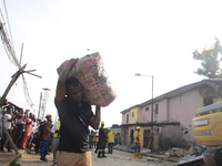 A man rescue some remains of his belongings after a building collapse at Gafari Balogun street, Ogudu area of Lagos on June 17, 2020. (