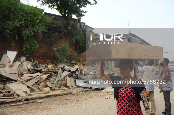 A woman rescue some remains of his belongings after a building collapse at Gafari Balogun street, Ogudu area of Lagos on June 17, 2020. 