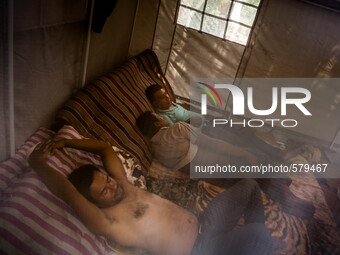 Men are taking rest inside a tent. Sankhu, Nepal. May 9, 2015. (