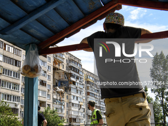 Locals watch Ukrainian rescue workers clean debris after a suspected gas explosion  in an apartment building in Kyiv, Ukraine, 21 June 2020....