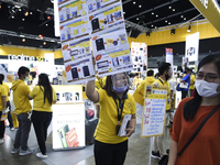 A salesperson wear protective facemasks offers discounts and promotions for Realme smartphones at the Thailand Mobile Expo 2020 in Bangkok,...