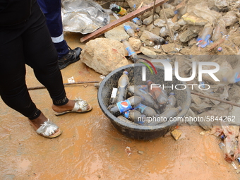 Occupants of the residents rescue the remains of their belongings among the ruins of a collapsed building, where three persons have been con...