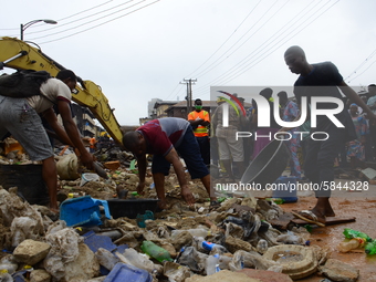 Occupants of the residents rescue some remains of their belongings among the ruins of a collapsed building, where three persons have been co...