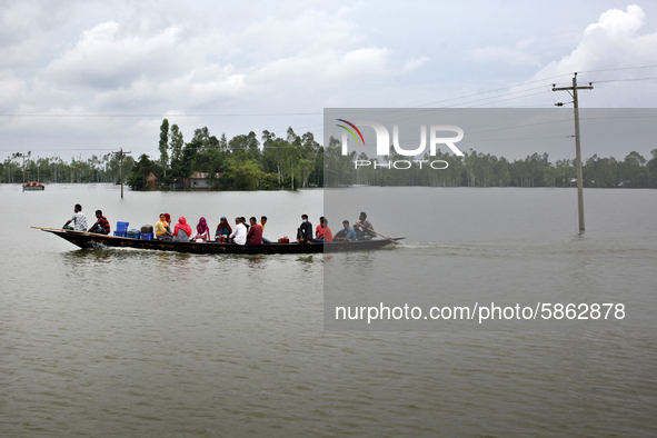 People ride on a boat through flood water at Jatrapur area in Kurigram, Bangladesh on Saturday, July 18, 2020. 