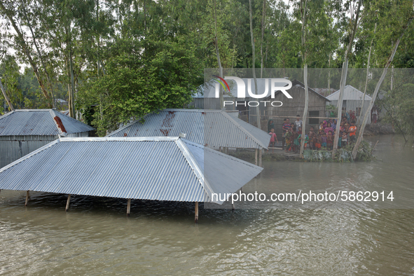 People wait for relief package as their home surrounded by the flood water at Jatrapur area in Kurigram, Bangladesh on Saturday, July 18, 20...