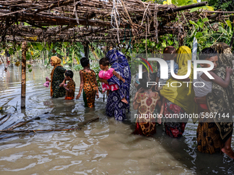Flood-affected people are seen on water as they wait for a boat to cross a stream in Jamalpur, Bangladesh, on July 20, 2020.  (