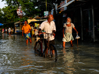 People walk on a flooded road in Jamalpur, Bangladesh, on July 20, 2020.  (