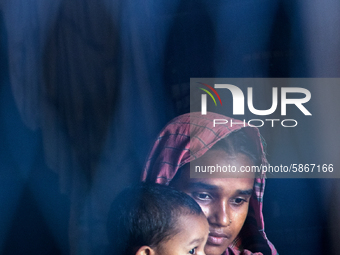 A flood-affected mother and daughter are seen inside a submurged house near Bogra, Bangladesh, on July 20, 2020.  (