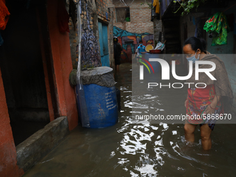 Nepalese woman walks through  flooded street following heavy monsoon rains, in Kathmandu, Nepal July 20, 2020. (