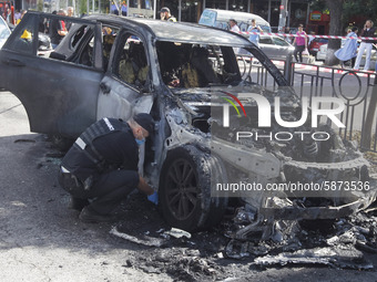 Ukrainian police officers work at the scene near a burned car in the center of Kyiv, Ukraine, on 22 July, 2020. Two parked cars on the roads...