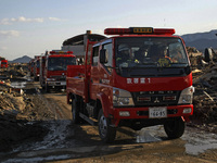 March 18, 2011-Rikuzen Takata, Japan-Rescue vehicle carry exhume body at Debris and Mud covered on Tsunami hit Destroyed city in Rikuzentaka...