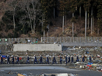 March 18, 2011-Rikuzen Takata, Japan-Rescue Team stop searching with going to their camp at Debris and Mud covered on Tsunami hit Destroyed...