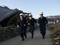 March 18, 2011-Rikuzen Takata, Japan-Rescue Team stop searching after going to their camp at Debris and Mud covered on Tsunami hit Destroyed...