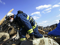 March 18, 2011-Rikuzen Takata, Japan-Rescue Team searching operation on debris and mud covered at Tsunami hit Destroyed city in Rikuzentakat...