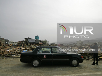 March 20, 2011-Rikuzen Takata, Japan-Taxi Driver take picture to hazard area on debris and mud covered at Tsunami hit Destroyed city in Riku...