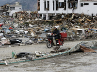 March 21, 2011-Ofunato, Japan-Postman working on debris and mud covered at Tsunami hit Destroyed Industrial Area in Ofunato on March 21, 201...