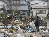 March 21, 2011-Ofunato, Japan-Native Survivor look military operation to debris and mud covered at Tsunami hit Destroyed Industrial Area in...
