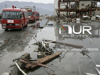 March 21, 2011-Ofunato, Japan-Rescue team searching burial body on debris and mud covered at Tsunami hit Destroyed Industrial Area in Ofunat...