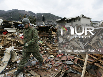 March 21, 2011-Ofunato, Japan-Military searching burial body on debris and mud covered at Tsunami hit Destroyed Industrial Area in Ofunato o...