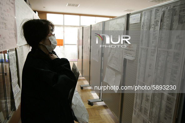 March 23, 2011-Rikuzen Takata, Japan-Native Survivor look missing person list with find their family name at refugee camp in Rikuzentakata o...