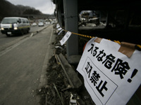 March 25, 2011-Kamaishi, Japan-Building side post warning card on debris and mud covered at Tsunami hit Destroyed mine town in Kamaishi on M...
