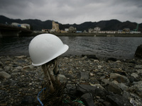 March 25, 2011-Kamaishi, Japan-Helmet hanging on a tree at debris and mud covered at Tsunami hit Destroyed mine town in Kamaishi on March 25...