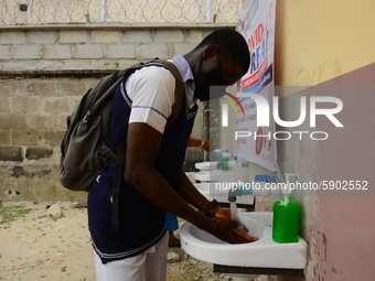 High school students wash their hands in a wash hand basin at the entrance of Ireti Junior Grammar Schol, Ikoyi, Lagos on August 3, 2020 on...