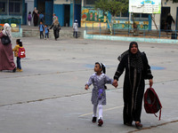 Women bring their children to the United-Nation run Elementary School on the first day of the new school year as Palestinians ease the coron...