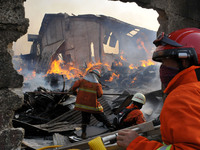 Officers extinguish the fire when a fire ravaged the wooden furniture factory building in Cakung, Jakarrta, on August, 9,2020. 30 units of f...