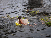 May 17, 2015 - Dhaka, Bangladesh - Children are taking shower in heavily polluted water of the Burigonga river. (