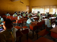 The final year students of Babs Fafunwa Millennium Senior Grammar School, Ojodu, Lagos, Nigeria sit with facemasks in a classroom as they wa...