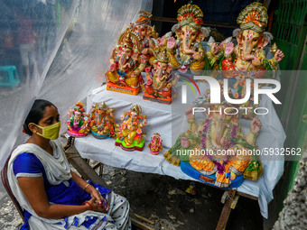 A lady wearing mask waits for customer for the Ganesha idols ahead of Ganesh puja at a potters hub in Kolkata.Ganesh chaturthi or Ganesh puj...