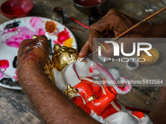 An artisan giving final touches to an idol of Ganesha.Ganesh chaturthi or Ganesh puja is the Hindu festival of celebrating the arrival of Lo...
