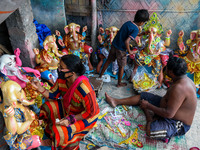 A family of artisan giving final touches to an idol of Ganesha.Ganesh chaturthi or Ganesh puja is the Hindu festival of celebrating the arri...