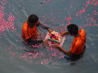 Volunteers immerse an idol of the Hindu god Ganesh, in an artificial pond during the Ganesh Chaturthi festival in Mumbai, India on August 23...