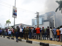 Crowed gather at the scene of a fire out break at Access Bank branch on Adetokunbo Ademola Street in Victoria Island in Lagos on August 26,...